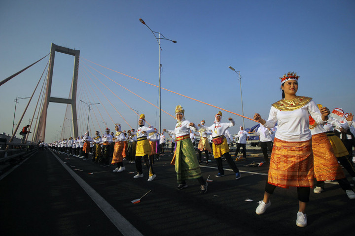 Ribuan peserta yang semuanya perempuan membawakan 'Tari Sajojo' saat memperingati Hari Ibu di bentang tengah Jembatan Suramadu, Surabaya, Jawa Timur, Sabtu, 7 Desember 2019.