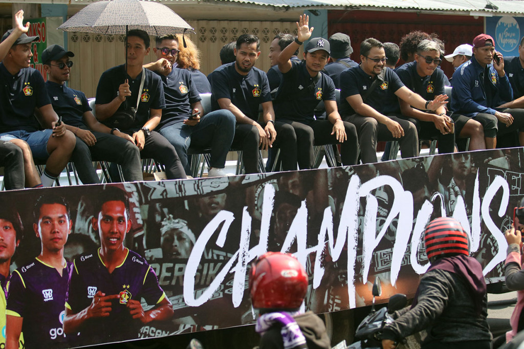 Pesepak bola Persik Kediri berada di atas truk trailer terbuka saat konvoi melintasi jalan protokol Kota Kediri, Jawa Timur, Sabtu, 7 Desember 2019.