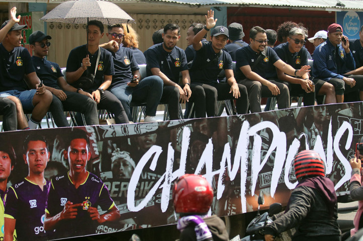 Pesepak bola Persik Kediri berada di atas truk trailer terbuka saat konvoi melintasi jalan protokol Kota Kediri, Jawa Timur, Sabtu, 7 Desember 2019.