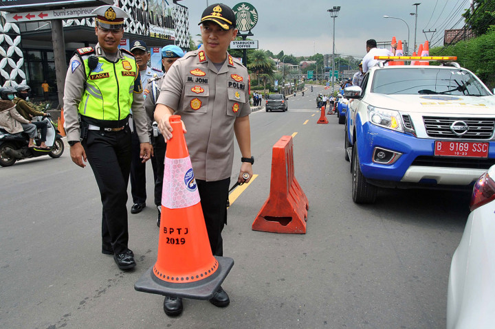 Kapolres Bogor AKBP Muhammad Joni (kanan) bersama Kasat Lantas Polres Bogor AKP Muhammad Fadli Amri memasang kerucut lalu lintas saat uji coba kedua sistem kanalisasi dua lajur arah turun dan satu lajur arah naik (2-1) di jalur Puncak, Ciawi.