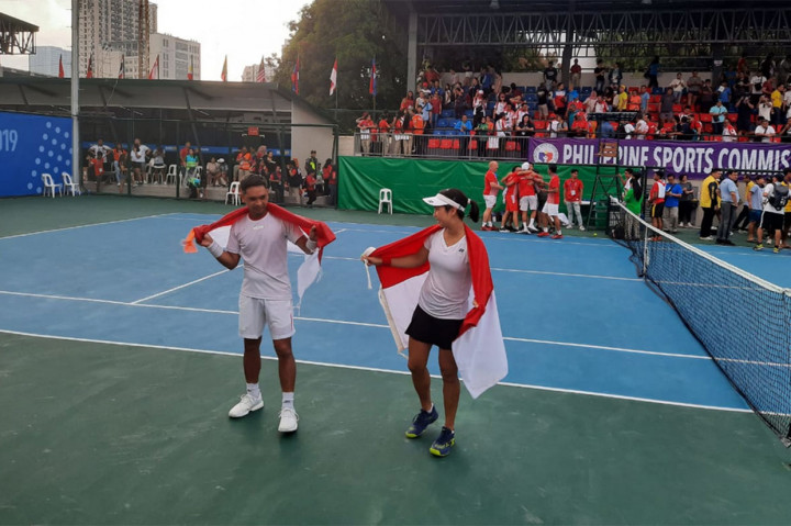 Ganda campuran Indonesia Christopher Rungkat/Aldila Sutjiad melakukan selebrasi usai meraih medaih emas setelah melewati laga dengan super tie-break kontra wakil Thailand Sanchai Ratiwatana/Tamarine Tanasugarn di partai final, Sabtu, 7 Desember 2019.
