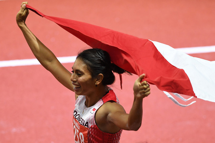 Atlet lompat jauh Indonesia Maria Natalia Londa membentangkan Bendera Merah Putih setelah berhasil memenangkan pertandingan Final Lompat Jauh Putri SEA Games ke-30 di Stadion Atletik New Clark, Filipina.