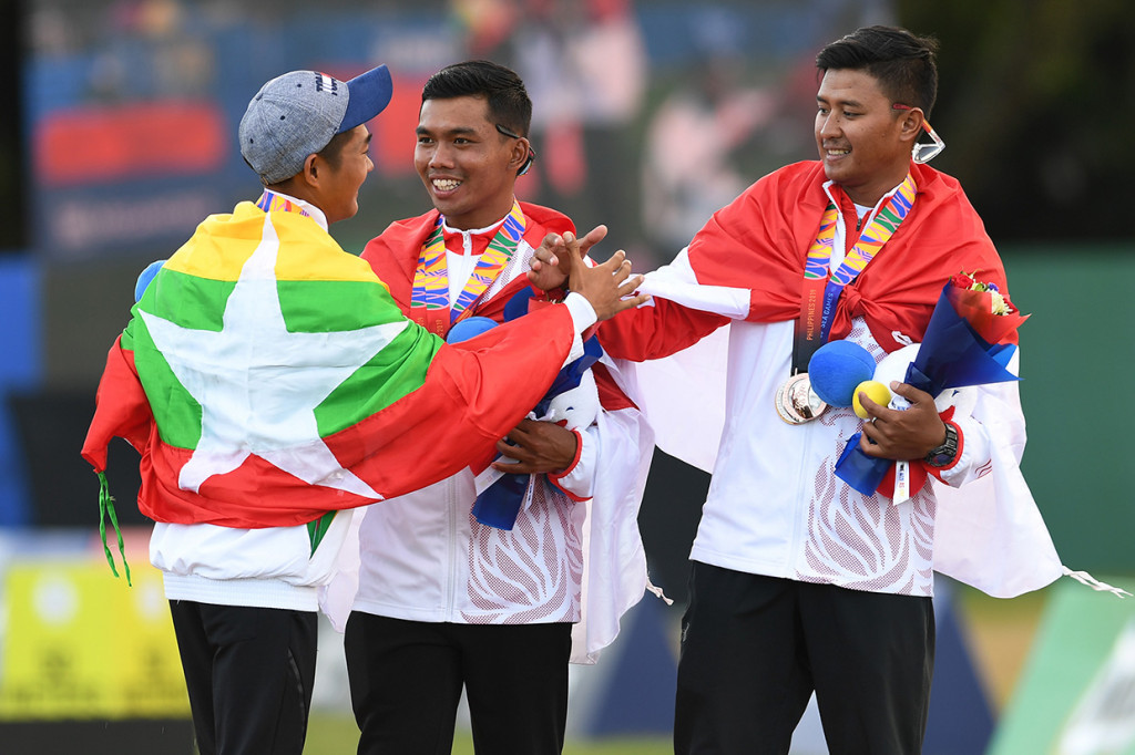 Atlet panahan Indonesia Hendra Purnama (tengah) dan Salsabila Agata Riau Ega (kanan) berjabat tangan dengan atlet panahan Myanmar Htike Lin Oo (kiri) seusai penganugerahan medali juara Panahan Recurve Individu Putra SEA Games ke-30 di Lapangan Parade Ground Clark Freeport, Filipina.
