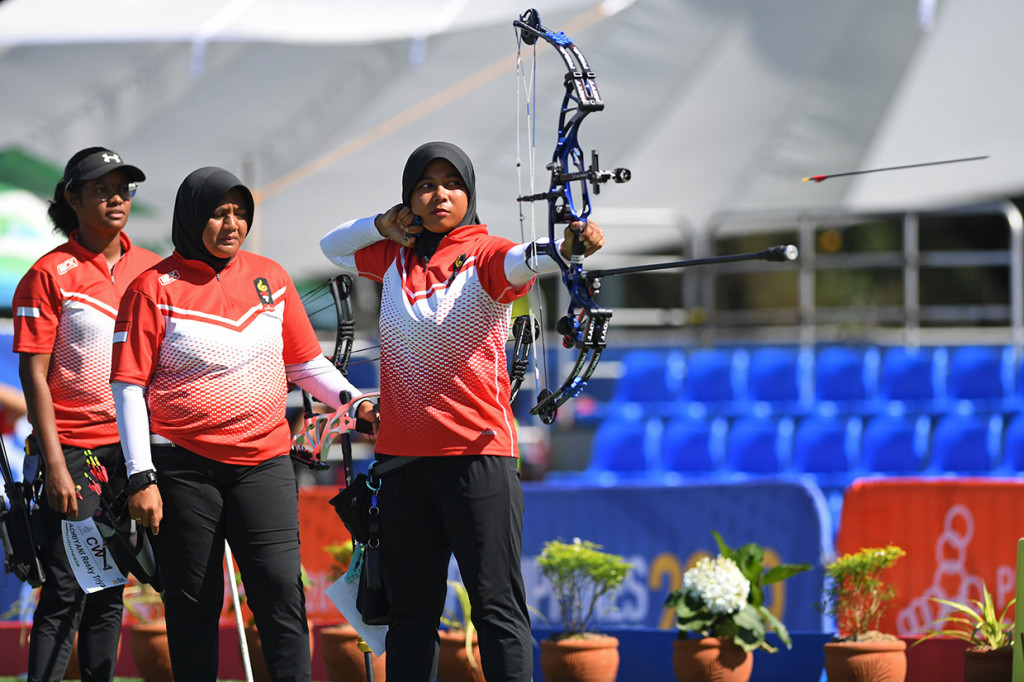 Tim panahan putri Indonesia Sri Ranti (kanan), Triya Resky Adriyani (tengah) dan Yurike Nina Bonita Pereira, melepaskan anak panah pada pertandingan Final Panahan Compound Tim Putri SEA Games ke-30 di Lapangan Parade Ground Clark Freeport, Filipina.

