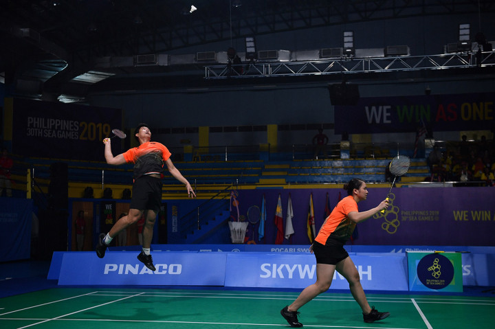 Ganda campuran Indonesia Praveen Jordan (kiri) dan Melati Daeva Oktavianti memukul kok ke arah ganda campuran Malaysia Goh Soon Huat dan Shevon Jemie Lai dalam final bulutangkis ganda campuran SEA Games 2019 di Kompleks Olahraga Muntinlupa, Manila, Filipina.