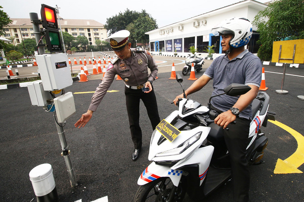 Kepala Seksi SIM Subdit Regident Ditlantas Polda Metro Jaya AKP Lalu Hedwin (kiri) menjelaskan cara mengikuti uji praktik SIM sistem elektronik di Satuan Penyelenggara Administrasi (Satpas) SIM Daan Mogot, Jakarta, Selasa, 10 Desember 2019.