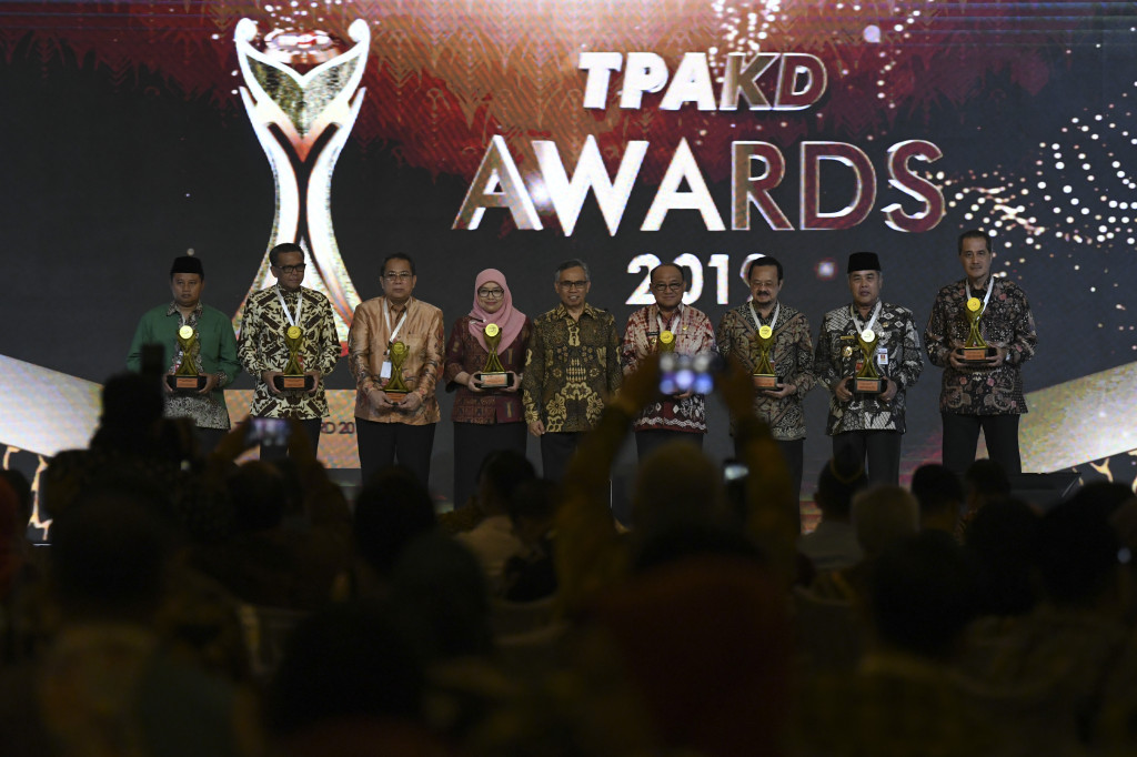 Ketua Dewan Komisioner Otoritas Jasa Keuangan (OJK) Wimboh Santoso (tengah) berfoto bersama dengan para penerima penghargaan TPKAD Award saat Rapat Koordinasi Nasional Tim Percepatan Akses Keuangan Daerah (TPAKD) dan Silahturahmi Nasional Bank Wakaf Mikro 2019 di Jakarta.