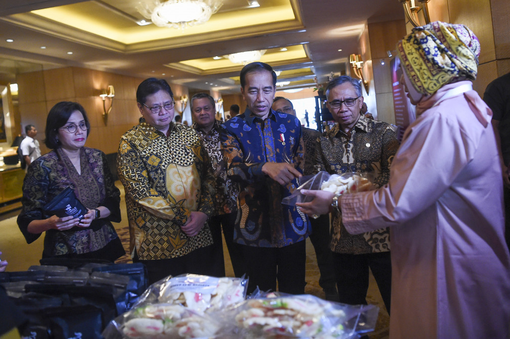 Presiden Joko Widodo (tengah) didampingi Ketua Dewan Komisioner Otoritas Jasa Keuangan (OJK) Wimboh Santoso (kedua kanan), Menteri Keuangan Sri Mulyani Indrawati (kiri), Menteri Koordinator Bidang Perekonomian Airlangga Hartarto (kedua kiri), Gubernur Bank Indonesia Perry Warjiyo (ketiga kiri) meninjau stan pameran di Rapat Koordinasi Nasional Tim Percepatan Akses Keuangan Daerah (TPAKD) dan Silahturahmi Nasional Bank Wakaf Mikro 2019 di Jakarta.