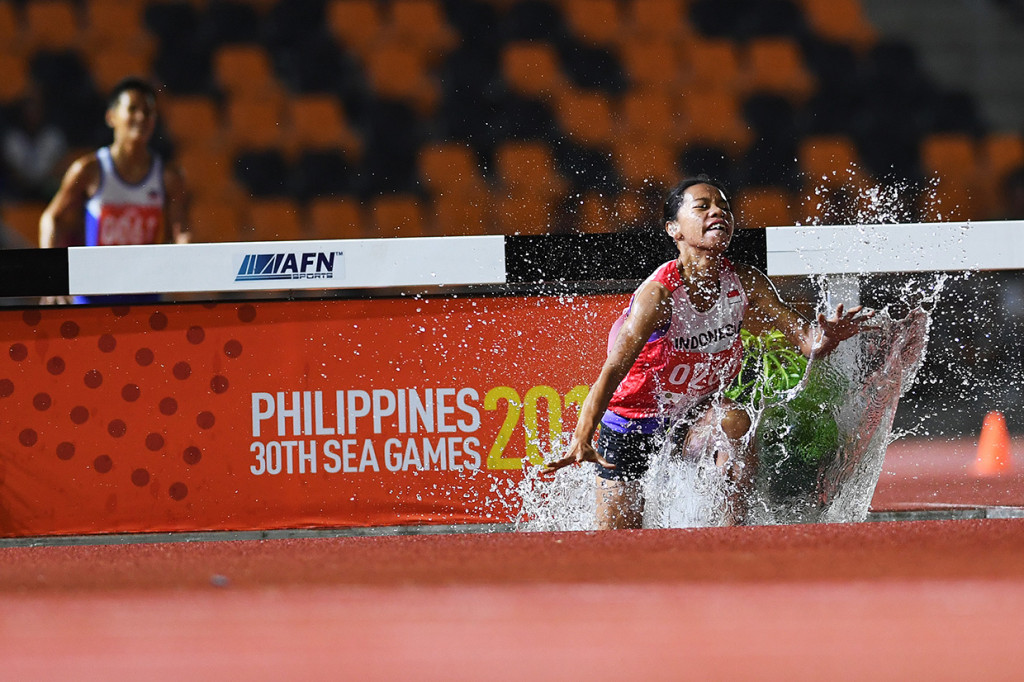 Pelari Indonesia Pretty Sihite (kanan) melewati rintangan saat final Lomba Lari Halang Rintang 3.000 Meter Putri SEA Games ke-30 di Stadion Atletik New Clark, Filipina. 