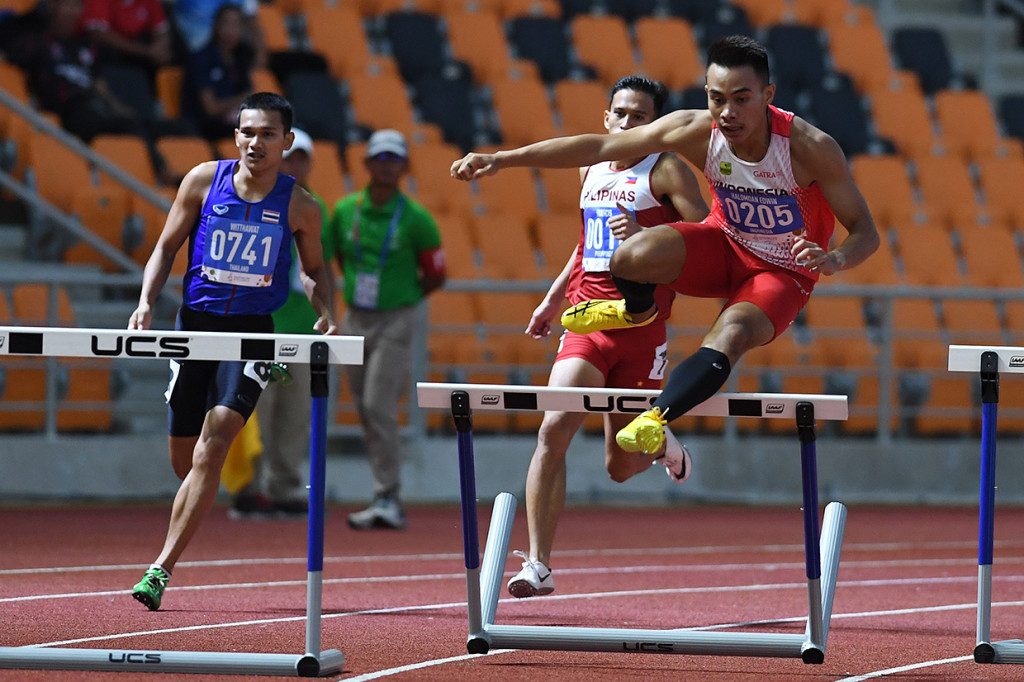 Pelari Indonesia Halomoan Edwin Binsar (kanan) melompati rintangan Lomba Lari Gawang 400 Meter Putra SEA Games ke-30 di Stadion Atletik New Clark, Filipina.