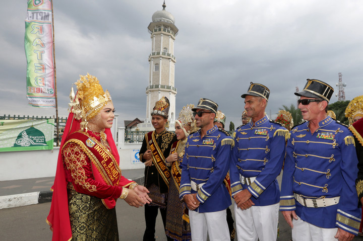 Inong wisata Kota Banda Aceh (kiri) berbincang dengan wisatawan asing yang mengikuti pawai pada karnaval budaya Koetaradja di Banda Aceh, Aceh. Karnaval ini selain untuk meningkatkan kunjungan wisatawan mancanegara juga bertujuan memperkenalkan adat istiadat dan budaya masyarakat Aceh serta keberagaman suku bangsa yang hidup rukun di Kota Banda Aceh. 
