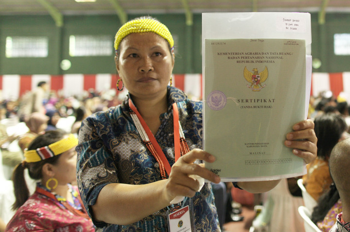 Salah satu warga menunjukan sertifikat tanah gratis yang dibagikan oleh Presiden Joko Widodo di Lapangan Tenis Indor Telaga Keramat, Tarakan, Kalimantan Utara.
