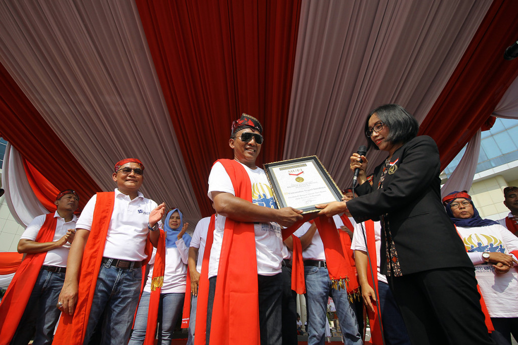 Rektor Unesa Nurhasan (tengah) menerima piagam penghargaan dari perwakilan Muri Ariyani Siregar usai penyelenggaraan 'flashmob' Tari Remo Milenial di halaman kampus Unesa. Prestasi ini tercatat dengan urutan yang ke-9.370.