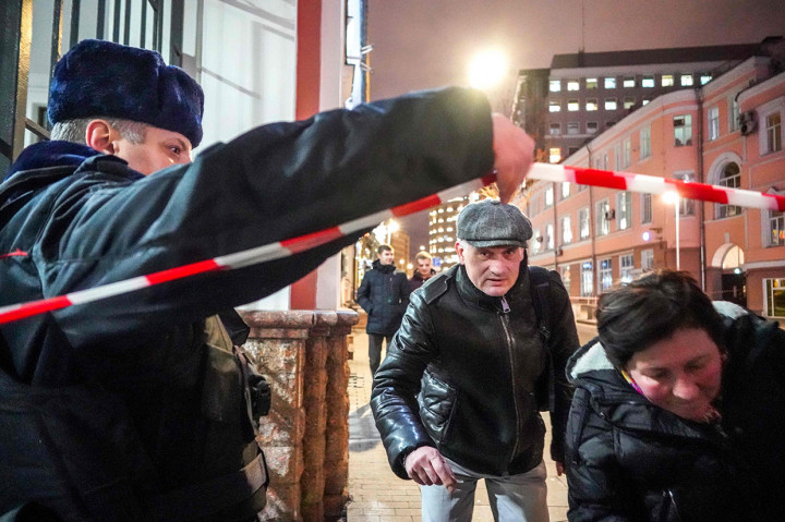 Rekaman yang diambil oleh warga yang lewat menunjukkan orang-orang berlarian panik sementara petugas bersenjata berjalan menuju tempat kejadian setelah insiden malam itu.