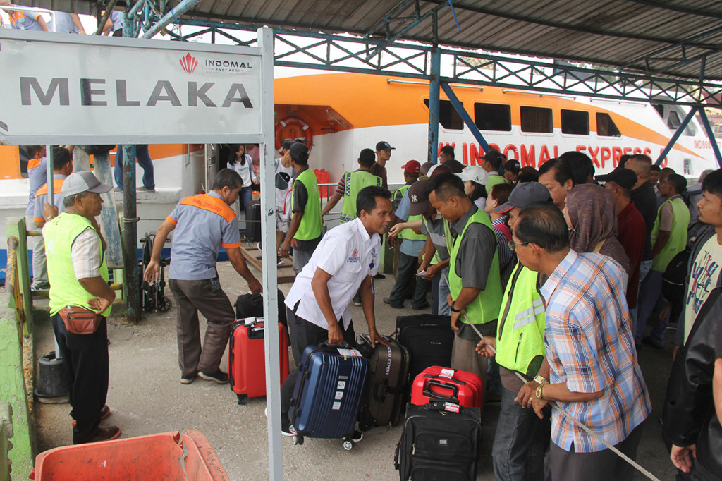 Sejumlah pekerja menurunkan bagasi milik penumpang kapal yang didominasi pemudik Natal dari Melaka di Pelabuhan Pelindo I Dumai di Dumai, Riau, Sabtu, 21 Desember 2019. Antara Foto/Aswaddy Hamid