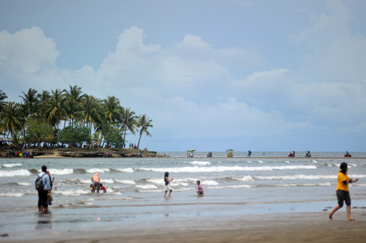 Sejumlah wisatawan menyeberang ke Pulau Pisang Kecil saat air laut surut di Pantai Air Manis, Padang, Sumatera Barat. Antara Foto/Iggoy el Fitra
