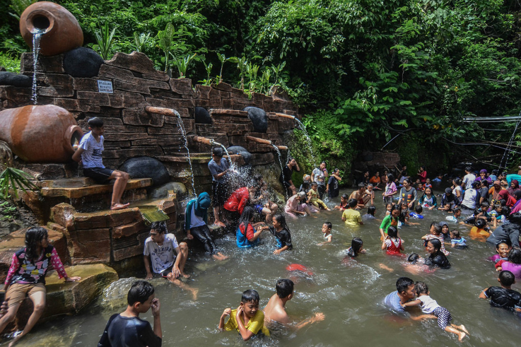Pengunjung menikmati wahana permainan air di Kawasan wisata Gunung Galunggung, Kabupaten Tasikmalaya, Jawa Barat. Antara Foto/Adeng Bustomi