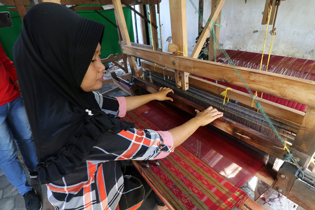Perajin memintal benang yang akan digunakan sebagai bahan pembuatan kain tenun ikat khas Kediri saat pembukaan Pasar Rakyat Kampung Tenun Ikat di Kelurahan Bandar Kidul, Kota Kediri, Jawa Timur. Antara Foto/Prasetia Fauzani