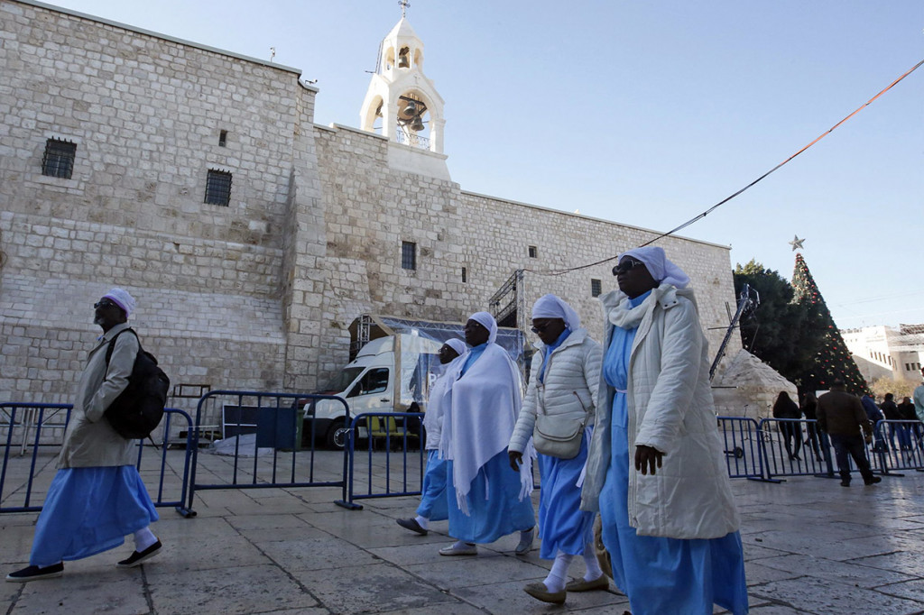 Ratusan turis dan penduduk setempat berkumpul di alun-alun di luar gereja, tempat pohon Natal setinggi 15 meter telah didirikan.