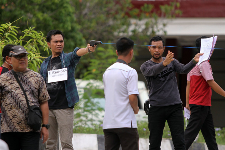 Tim Inafis Polda Sulawesi Tenggara memegang miniatur senjata api ketika melakukan rekonstruksi penembakan mahasiswa Universitas Haluoleo Kendari almarhum Randi saat aksi unjuk rasa di depan Gedung DPRD Provinsi Sulawesi Tenggara di Kecamatan Mandonga, Kendari, Sulawesi Tenggara, Selasa, 24 Desember 2019.