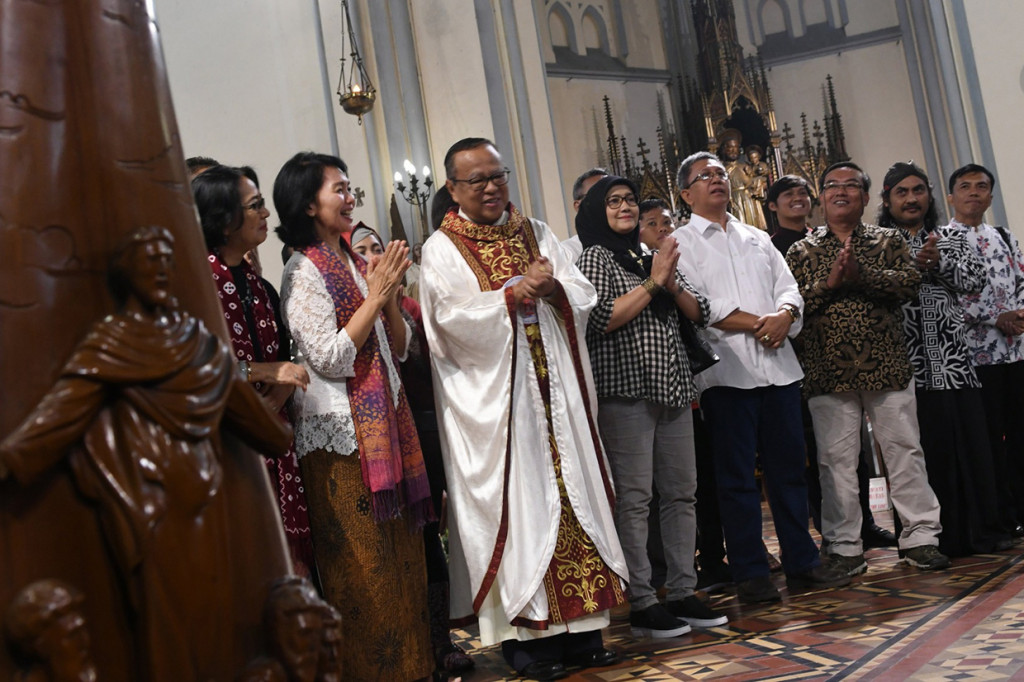 Sejumlah anggota komunitas lintas agama berdoa bersama saat mengunjungi ibadah Misa Natal di Gereja Katedral, Jakarta, Rabu, 25 Desember 2019. 