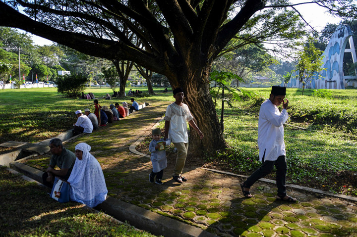 Keluarga berdoa dengan membaca surat Yassin saat berziarah pada peringatan 15 tahun bencana tsunami Aceh di kuburan massal korban, Desa Siron, Aceh Besar, Aceh, Kamis, 26 Desember 2019. AFP Photo/Chaideer Mahyuddin