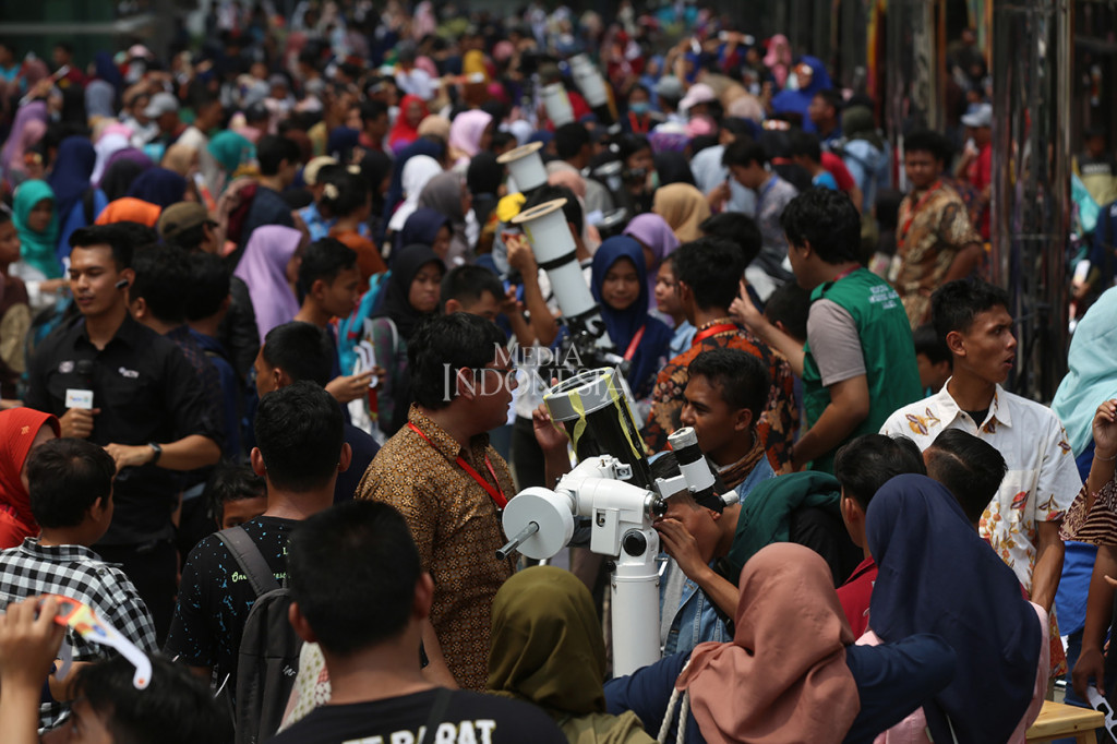 Ribuan warga antusias menyaksikan fenomena alam gerhana matahari cincin, di Planetarium Jakarta, Kamis, 26 Desember 2019.