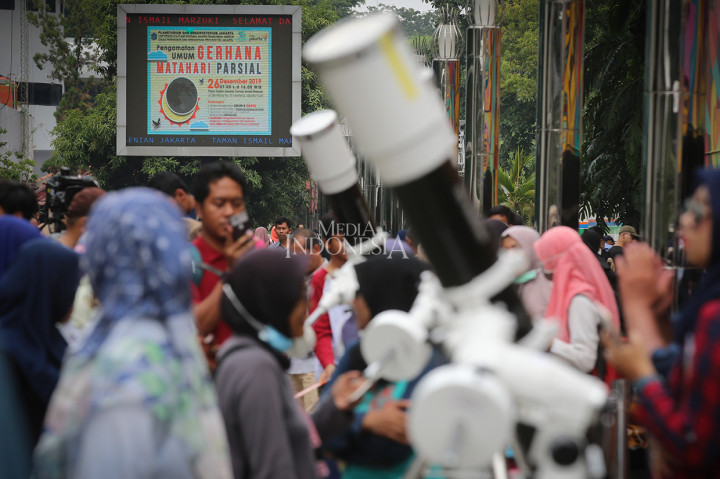 Warga antre menggunakan teropong yang disiapkan di Planetarium Jakarta untuk mengamati fenomena alam gerhana matahari. Sementara sebagian lainnya mengamati fenomena alam gerhana matahari dengan menggunakan kacamata khusus.