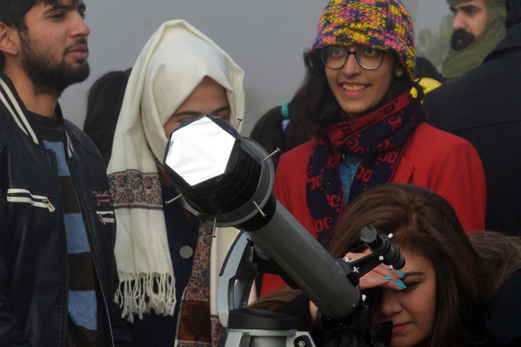 Warga Pakistan menyaksikan fenomena gerhana matahari cincin menggunakan teleskop di Islamabad. AFP Photo/Farooq Naeem