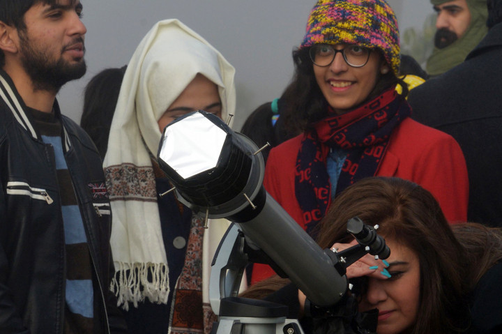 Warga Pakistan menyaksikan fenomena gerhana matahari cincin menggunakan teleskop di Islamabad. AFP Photo/Farooq Naeem
