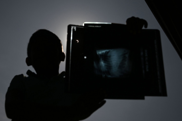 Seorang anak menggunakan film x-ray untuk menyaksikan gerhana matahari cincin di Kolombo, Sri Lanka. AFP Photo/Lakruwan Manniarachchi