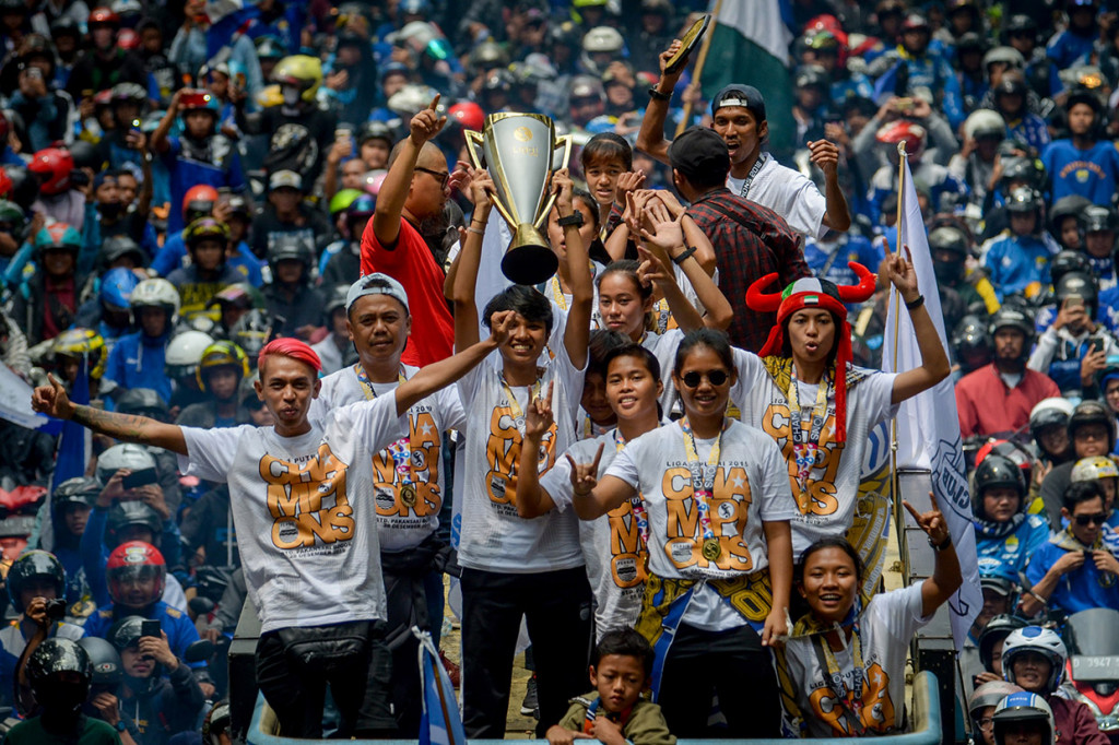 Ofisial bersama Tim Persib Putri menunjukan piala saat arak-arakan keliling Kota Bandung, Jawa Barat. 