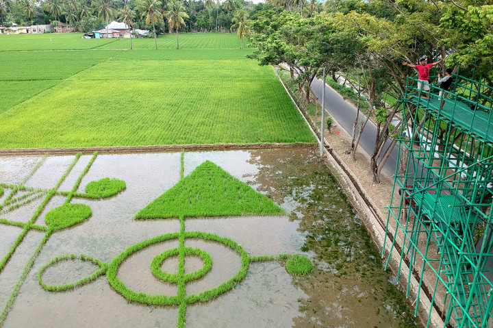 Sejumlah pengunjung menyaksikan ekspresi seni Land Art Not Khatulistiwa karya perupa Iwan Yusuf di Desa Huntu Selatan, Kabupaten Bone Bolango, Gorontalo.