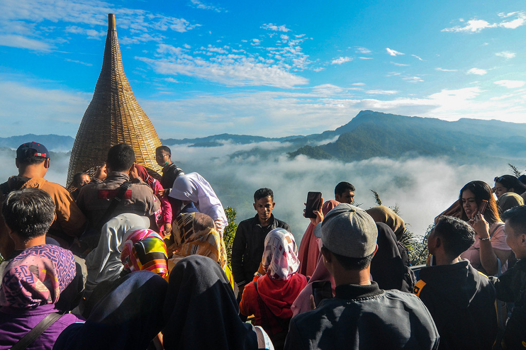 Pengunjung menikmati pemandangan dari Puncak Bangku, Desa Situmandala, Kecamatan Rancah, Kabupaten Ciamis, Jawa Barat.