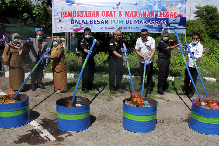 Kepala Balai Besar Pengawas Obat dan Makanan (BBPOM) Makassar Abdul Rahim (keempat kanan) bersama Direskrim Narkoba Polda Sulawesi Selatan Kombes Pol Hermawan (ketiga kanan) memusnahkan barang bukti di pelataran kantor BBPOM Makassar, Sulawesi Selatan.