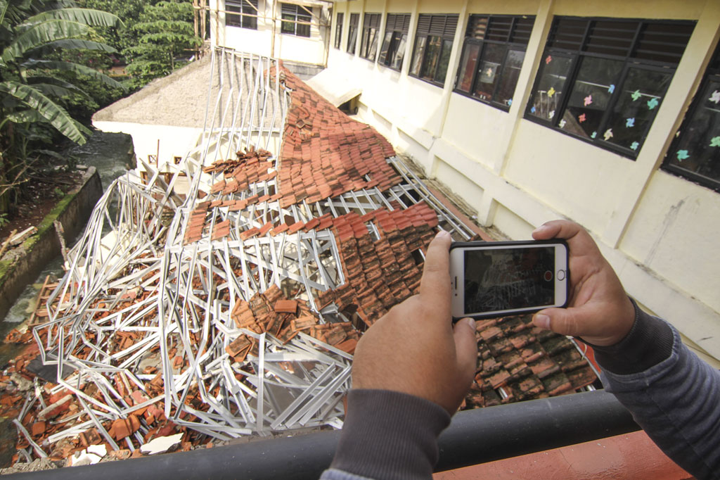 Pergeseran kontur tanah akibat hujan dan tingginya aliran air kali yang berada di samping bangunan perpustakaan mengakibatkan bangunan tersebut ambruk.