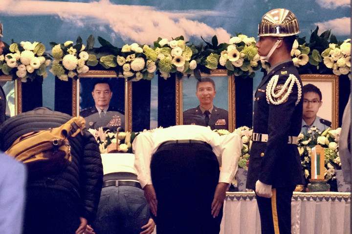 Kerabat memberikan penghormatan di depan foto korban tewas kecelakaan helikopter militer Black Hawk, termasuk Panglima Militer Taiwan, Shen Yi-Ming (kiri), di sebuah rumah duka di Taipei, Jumat, 3 Januari 2020.