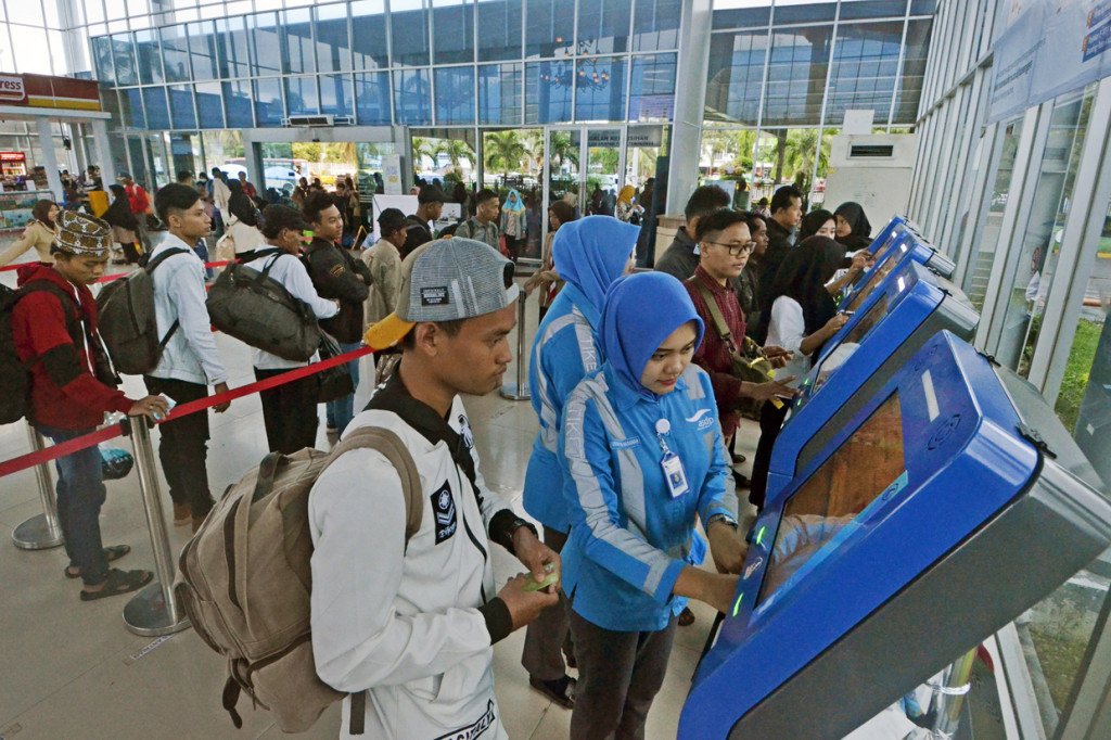 Petugas membantu sejumah calon penumpang yang akan membeli tiket kapal Roro melalui mesin Vending Machine di Pelabuhan Bakauheni Lampung Selatan, Lampung.