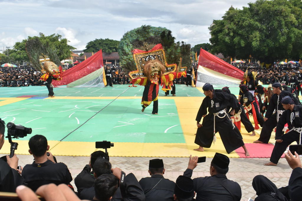 Sejumlah pesilat memeragakan gerakan silat yang dipadukan dengan tarian seni Reog Ponorogo pada acara Bumi Reyog Berzikir 2020 di Alun-alun Ponorogo, Jawa Timur.