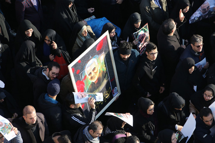 Para pelayat yang hadir tampak memegang foto Soleimani yang dianggap sebagai pahlawan tanpa pamrih oleh banyak warga Iran. 
