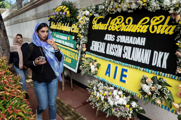 Warga berjalan di luar gedung Kedutaan Besar Iran di Indonesia yang dipenuhi karangan bunga duka cita tewasnya Komandan Pasukan Quds Garda Revolusi Iran, Jenderal Qasem Soleimani, di Menteng, Jakarta, Selasa, 7 Januari 2020.