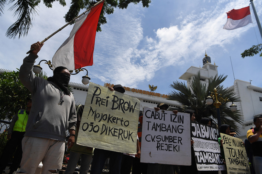 Sejumlah pengunjuk rasa yang tergabung dalam Aliansi Masyarakat Peduli Lingkungan membentangkan poster saat aksi setop tambang galian C di Mojokerto di depan Kantor Gubernur Jawa Timur, Surabaya, Jawa Timur.