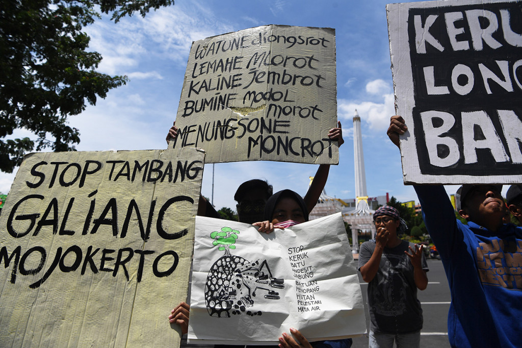 Sejumlah pengunjuk rasa yang tergabung dalam Aliansi Masyarakat Peduli Lingkungan membentangkan poster saat aksi setop tambang galian C di Mojokerto di depan Kantor Gubernur Jawa Timur, Surabaya, Jawa Timur.