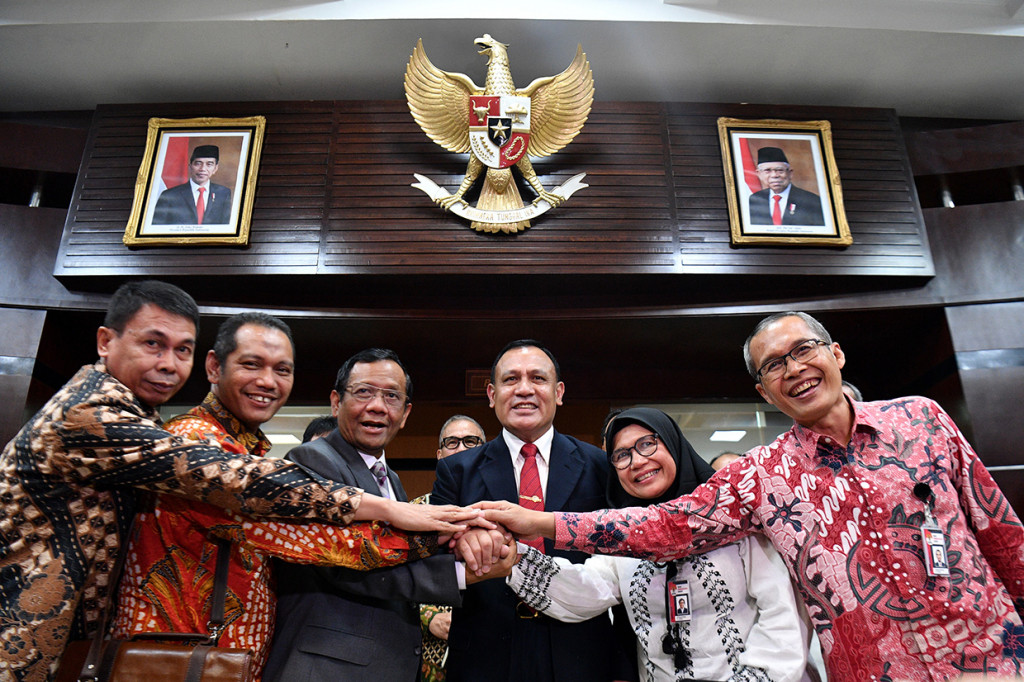 Menko Polhukam Mahfud MD (ketiga kiri) menyatukan tangan dengan Ketua KPK Firli Bahuri (ketiga kanan) dan para Wakil Ketua KPK Nawawi Pomolango (kiri), Nurul Ghufron (kedua kiri), Lili Pintauli Siregar (kedua kanan), dan Alexander Marwata, usai konferensi pers di Kantot Kemenkopolhukam, Jakarta.