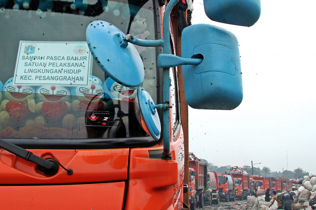 Truk pengangkut sampah antre untuk menurunkan muatan sampah pasca banjir di lahan tambahan Zona III Tempat Pengolahan Sampah Terpadu (TPST) Bantar Gebang, di Bekasi, Jawa Barat. Pemerintah Kota Bekasi bekerja sama dengan Pemerintah Provinsi DKI Jakarta dalam perizinan pembuangan sampah di lahan TPST tersebut akibat tingginya volume sampah pasca banjir yang melebihi kapasitas di TPA Sumur Batu.