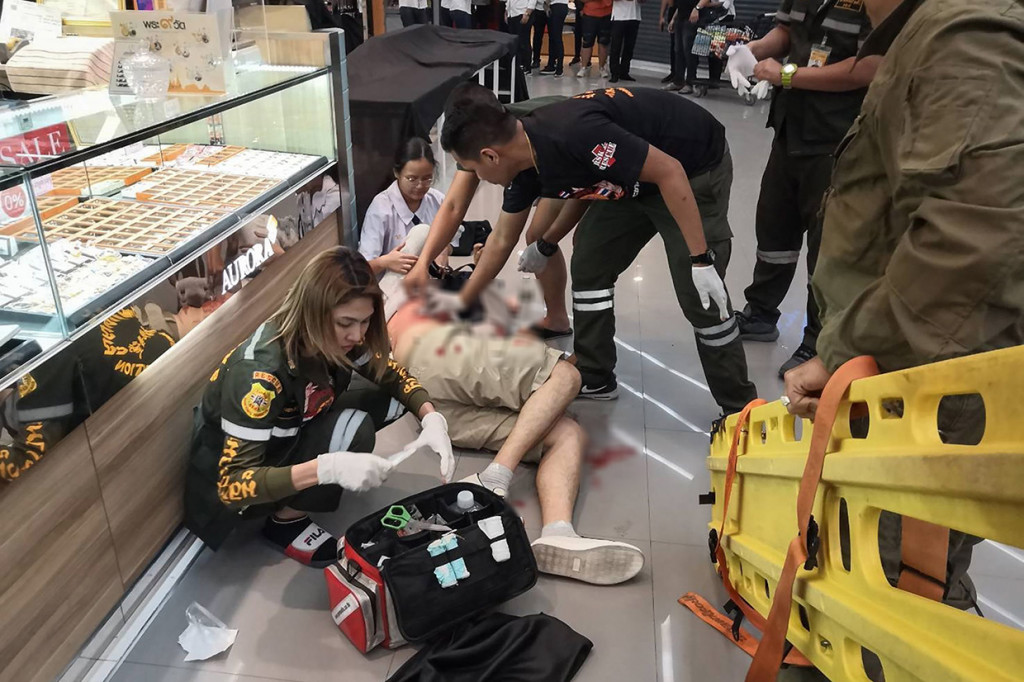 Paramedis membantu seorang pria yang terluka dalam perampokan di pusat perbelanjaan Robinson di Kota Lopburi, sekitar 150 kilometer utara Bangkok, Kamis, 9 Januari 2020.