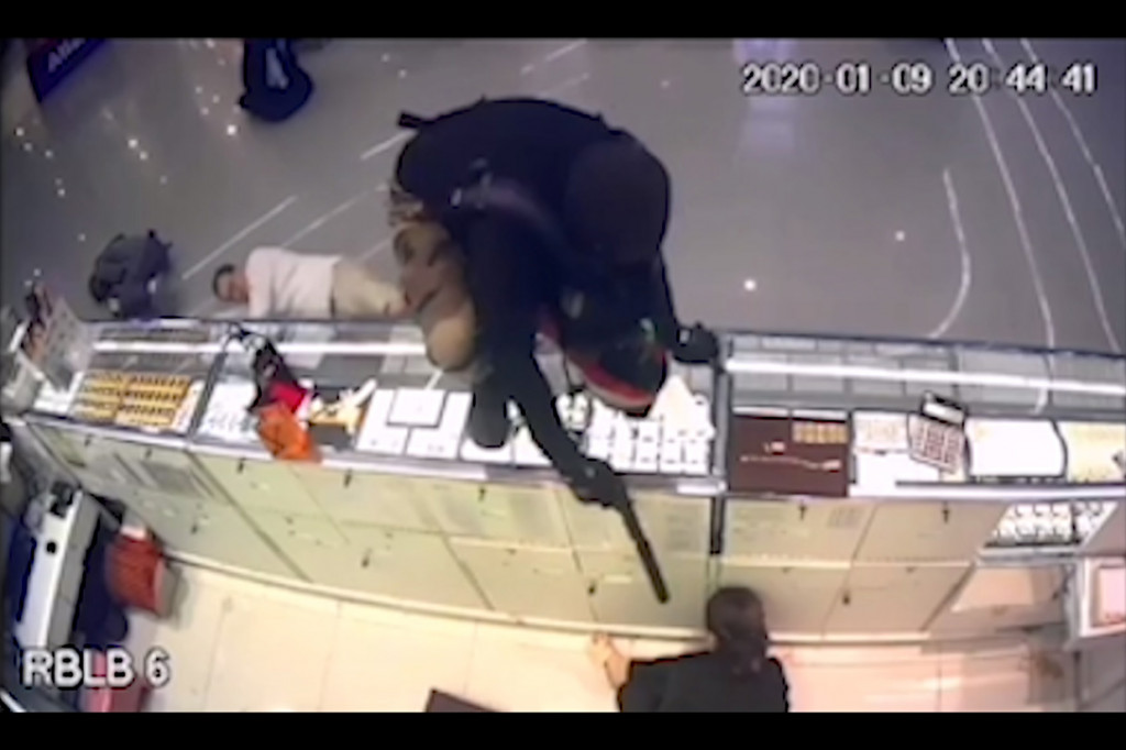 Rekaman CCTV menunjukkan pelaku menyerbu masuk ke toko, melepaskan tembakan, dan melompati konter saat para korban mengerang kesakitan di lantai.