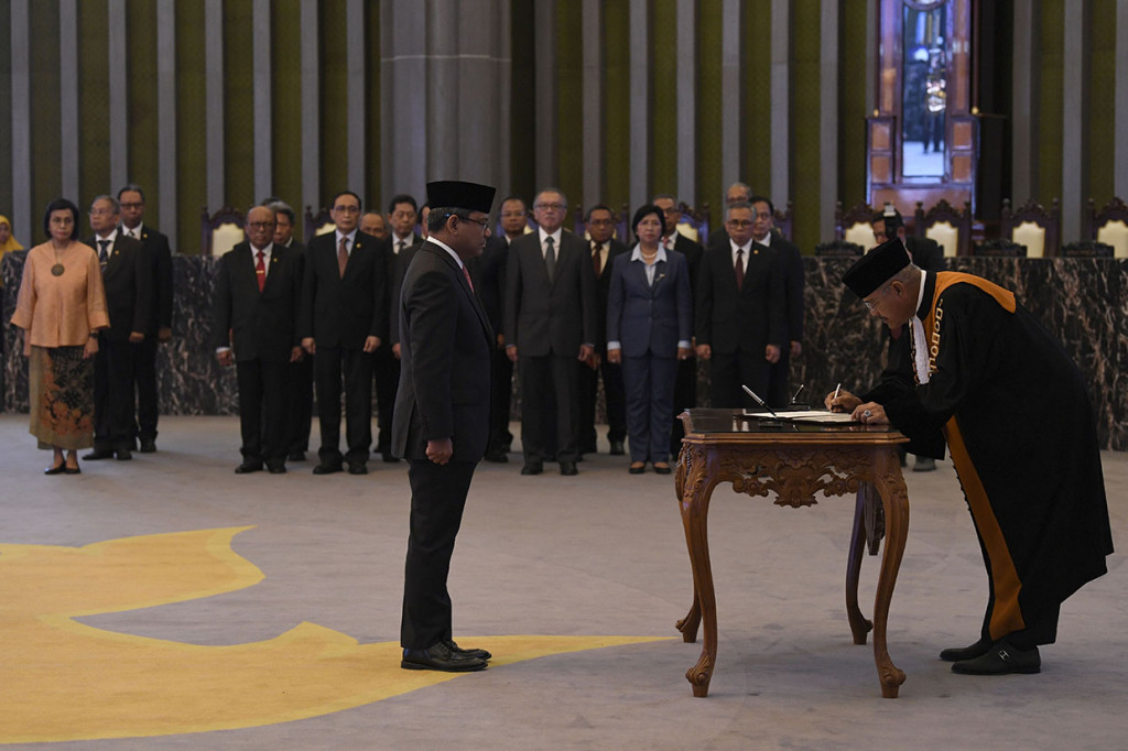 Ketua Mahkamah Agung M Hatta Ali (kanan) menandatangani berita acara pengucapan sumpah jabatan anggota Dewan Komisioner Otoritas Jasa Keuangan Ex-Officio Kementerian Keuangan Suahasil Nazara (kiri) di Mahkamah Konstitusi, Jakarta.