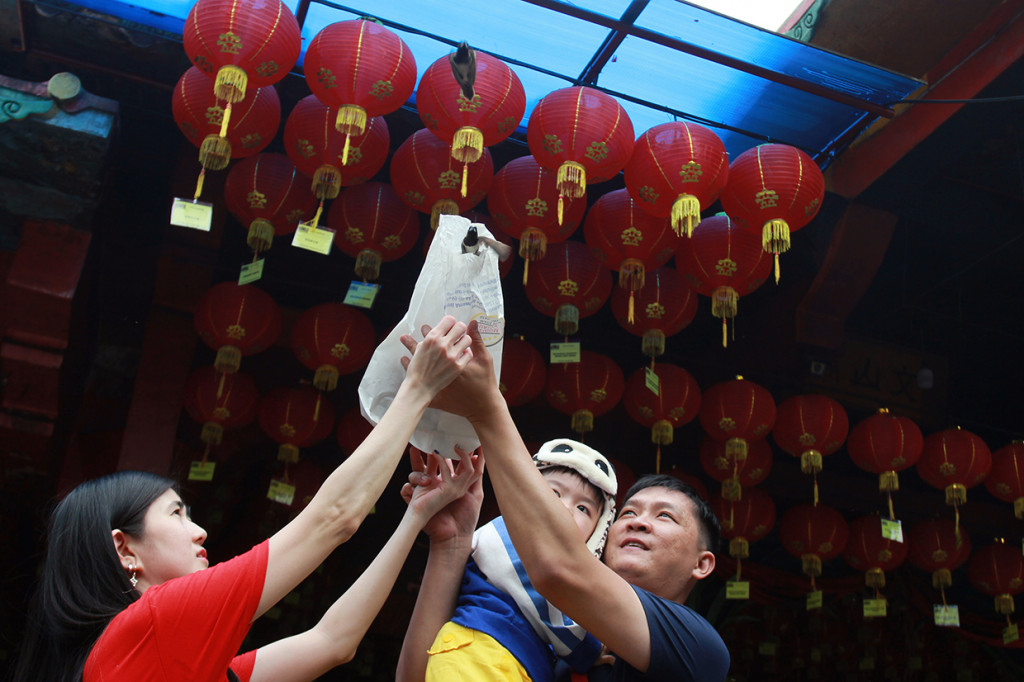 Satu keluarga etnis Tionghoa melakukan ritual Kias Pangsen atau pelepasan mahluk hidup di Vihara Boen San Bio, Tangerang, Banten. Ritual Pangsen merupakan ritual yang dilakukan jelang Tahun Baru Imlek, untuk mendapatkan keberuntungan dan kebahagiaan saat tahun baru. ANTARA FOTO/Muhammad Iqbal