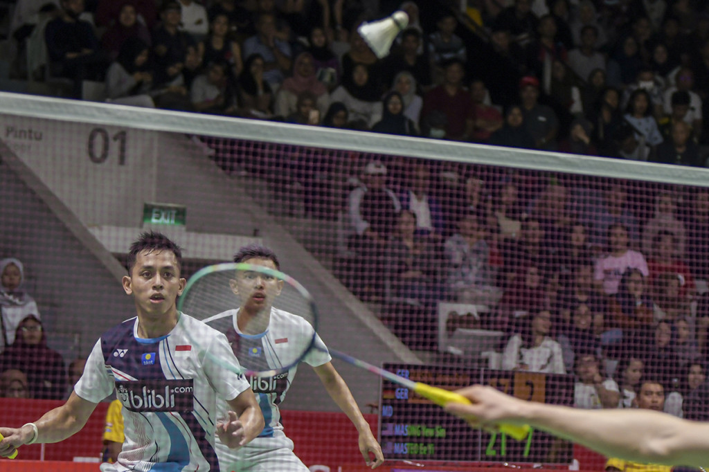Pebulu tangkis ganda putra Indonesia Muhammad Rian Ardianto (kiri) dan rekannya Fajar Alfian mengembalikan kok ke arah lawannya asal Tiongkok Ou Xuan Yi dan Zhang Nan dalam pertandingan babak 16 besar Daihatsu Indonesia Masters 2020 di Istora Senayan, Jakarta.